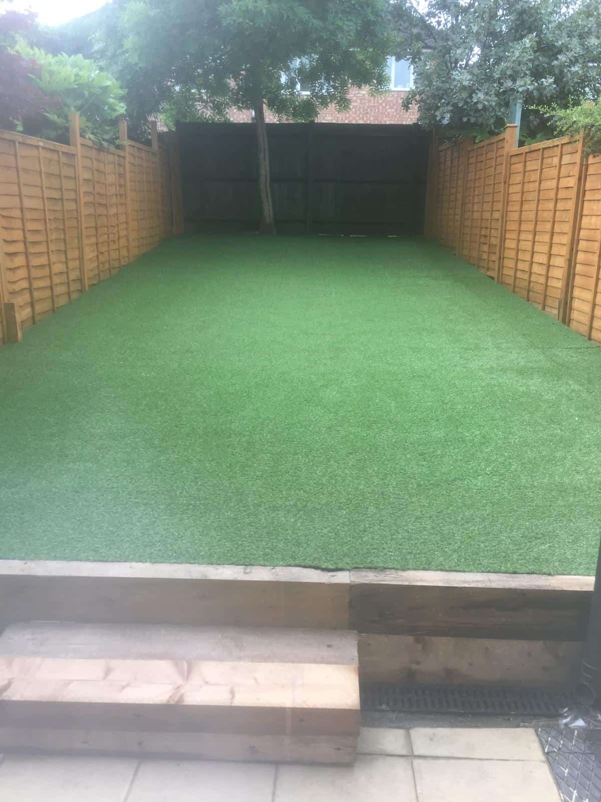 Artificial Grass Gloucester Completed artificial grass installation with raised beds in a Gloucestershire garden