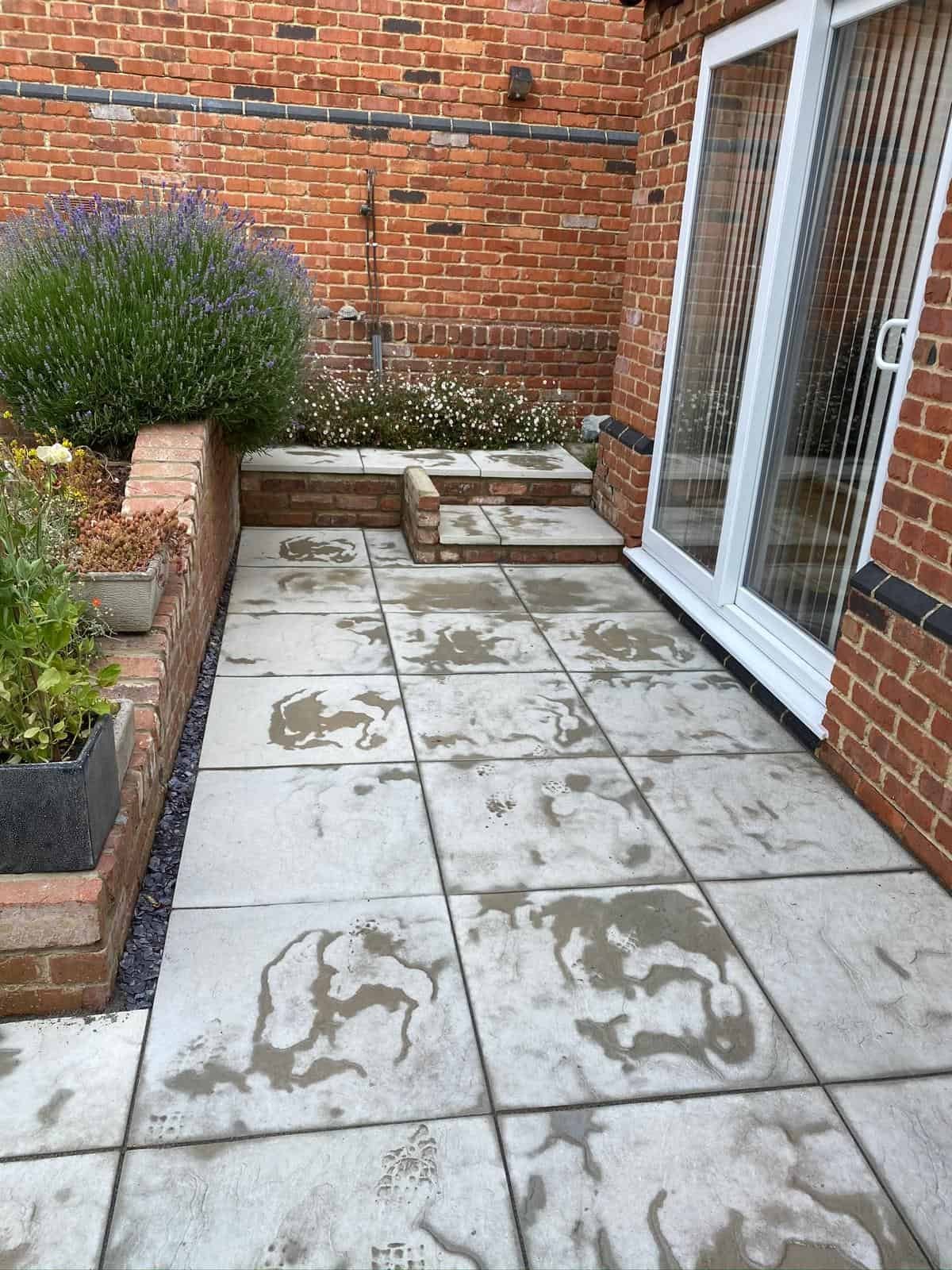 patios Gloucester After - Completed Indian sandstone patio with fresh turf and borders in Gloucestershire